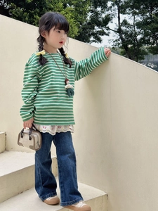 Mini sac à main assorti à un haut rayé vert et un pantalon en jean bleu marine