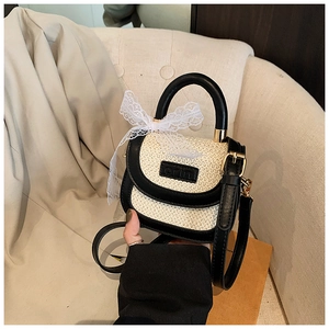 Détail du mini sac en paille avec nœud en dentelle, garniture en cuir et bandoulière