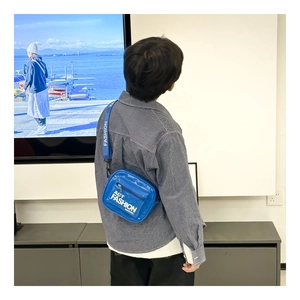 Detail of royal blue kids crossbody bag with adjustable wide strap and bold white lettering