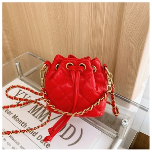 Détail du sac seau matelassé rouge avec cordon de serrage et bandoulière chaîne dorée