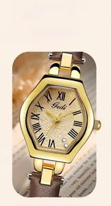 Detail of vintage ladies quartz watch with gold hexagonal dial and brown leather strap on book
