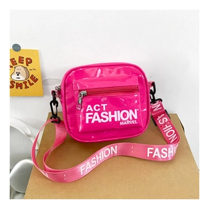 Detail of bright pink patent leather kids bag with wide letter-printed shoulder strap