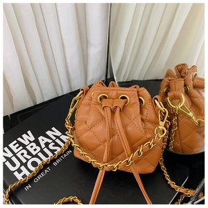 Détail du sac seau matelassé marron avec bandoulière en chaîne dorée et cordon