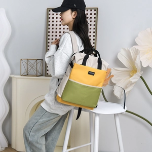 Stylish color-block diaper bag backpack in beige, yellow, and green for modern mothers