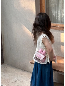 Detailed view of kids' pink sequin crossbody bag with a cute bow and gold chain strap