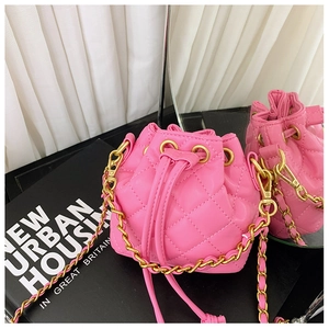 Détail du sac seau matelassé rose avec cordon de serrage et bandoulière chaîne dorée