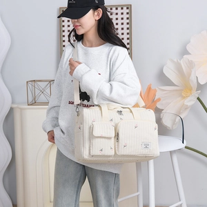 Quilted beige diaper bag with pink tulip embroidery and adjustable shoulder strap
