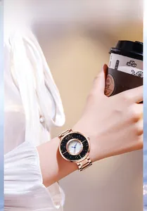 Détail d'une montre pour femme en or rose avec anneau de sable étoilé et cadran en nacre