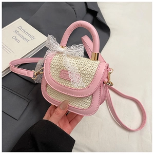 Détail du sac enfant en simili cuir rose et paille tressée avec nœud en dentelle et logo