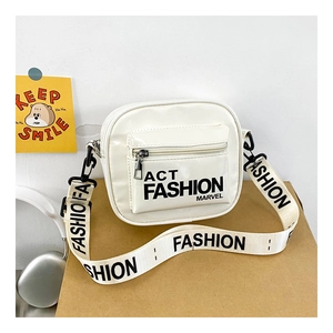 Detail of white patent leather kids crossbody bag with black lettered fashion straps