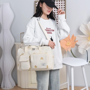 Quilted cream baby diaper bag with bear print featuring multi-pockets and shoulder strap