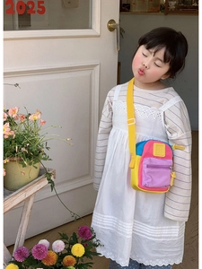 Detail of colorful canvas crossbody bag with adjustable strap worn by child model
