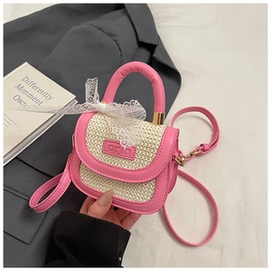 Détail du mini sac en paille et cuir rose avec nœud en dentelle et logo embossé