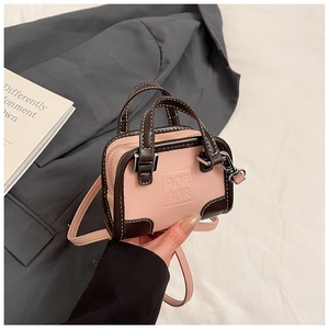 Détail d'un mini sac pour fille rose et marron avec lettres gaufrées et bandoulière
