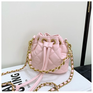 Détail d'un sac seau rose matelassé avec cordon de serrage et bandoulière en chaîne