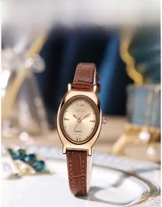 Vue macro d'une montre ovale élégante en or rose avec bracelet en cuir marron