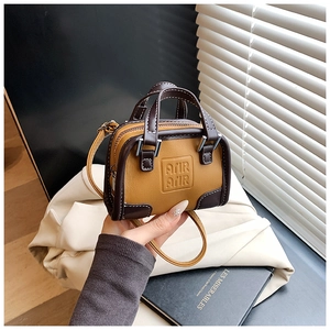 Détail du mini sac à main bicolore pour filles avec lettres embossées et coutures