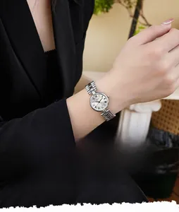 Close-up of vintage silver Roman numeral watch on wrist featuring a multi-link metal strap