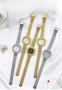 Relojes de cuarzo de lujo con biseles de diamante y correas milanesas sobre seda blanca