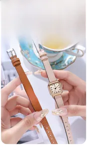 Close-up of vintage square women watches with leather straps and gold cases in hand