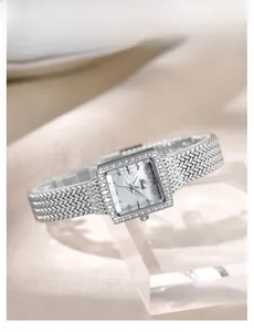 Macro detail of silver square watch face with mother of pearl dial and crystal bezel