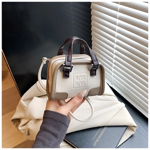Détail du mini sac Boston bicolore avec bandoulière réglable et logo AMIR AMIR gravé
