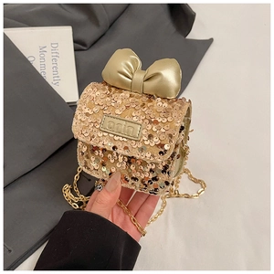 Detailed view of gold sequin mini bag featuring a large bow and elegant chain strap
