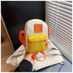 Close-up of contrast color mini canvas shoulder bag with orange label and yellow front pocket