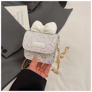 Detail of girls mini sequin crossbody bag with large white bow and gold chain strap