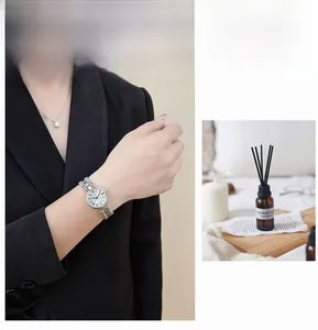 Detail of silver vintage watch with Roman numerals and metal bracelet on woman's wrist