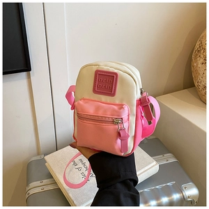 Close-up of a mini canvas crossbody bag in beige and pink with adjustable shoulder strap