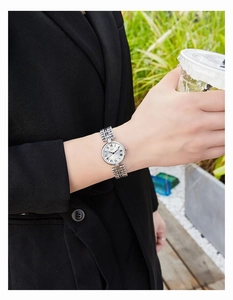 Silver vintage women's watch with Roman numerals and metal chain strap on wrist