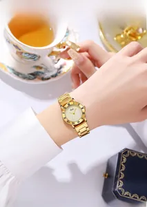 Gros plan d'une montre rétro en or à quartz avec lunette romaine sur un poignet