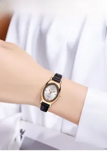 Gros plan d'une montre à quartz pour femme avec boîtier ovale doré rose et bracelet noir