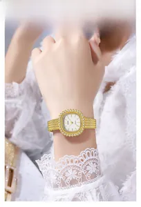 Primer plano de reloj dorado elegante con bisel de diamantes en muñeca femenina