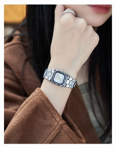 Close-up of elegant octagonal white dial watch with silver strap on female wrist