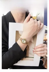 Detail of vintage gold watch with Roman numerals and elegant metal chain strap