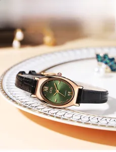 Vue détaillée d'une montre à quartz ovale élégante avec cadran vert sur une assiette blanche