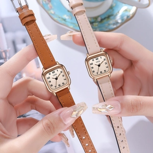 Elegant women's square quartz watch with gold case and leather strap on floral plate
