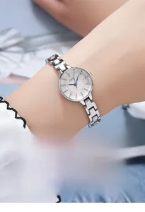 Close-up of GEDI watch with wood grain spark dial and elegant blue hands on silver band
