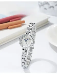 Detail view of GEDI silver bracelet watch with a white dial and blue hands on a desk