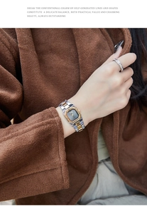 Close-up of a vintage hexagonal two-tone steel watch and a gold ring on a woman's wrist