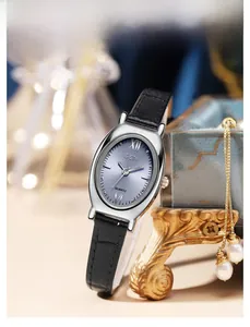 Gros plan sur la montre ovale en argent avec cadran bleu soleil et bracelet en cuir noir