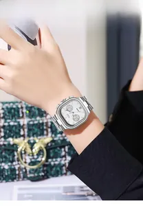 Detail of square silver steel watch with chronograph dials on model with green bag