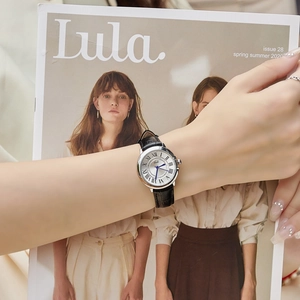 Classic silver ladies watch with blue hands and black leather strap on lifestyle background