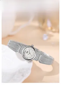 Vue détaillée d'une montre en nacre avec bracelet en maille sur une assiette en céramique