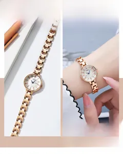 Detail of rose gold small round dial watch with metal chain strap on woman's wrist