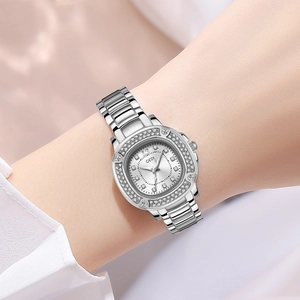 Luxuriöse silberne Quarzuhr mit Strass-Lünette und Stahlarmband am Handgelenk