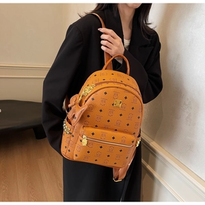 Detail of caramel brown backpack featuring cartoon bear print and gold metallic hardware
