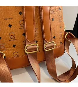 Detail of adjustable long shoulder strap and golden metal buckle on brown bear print backpack